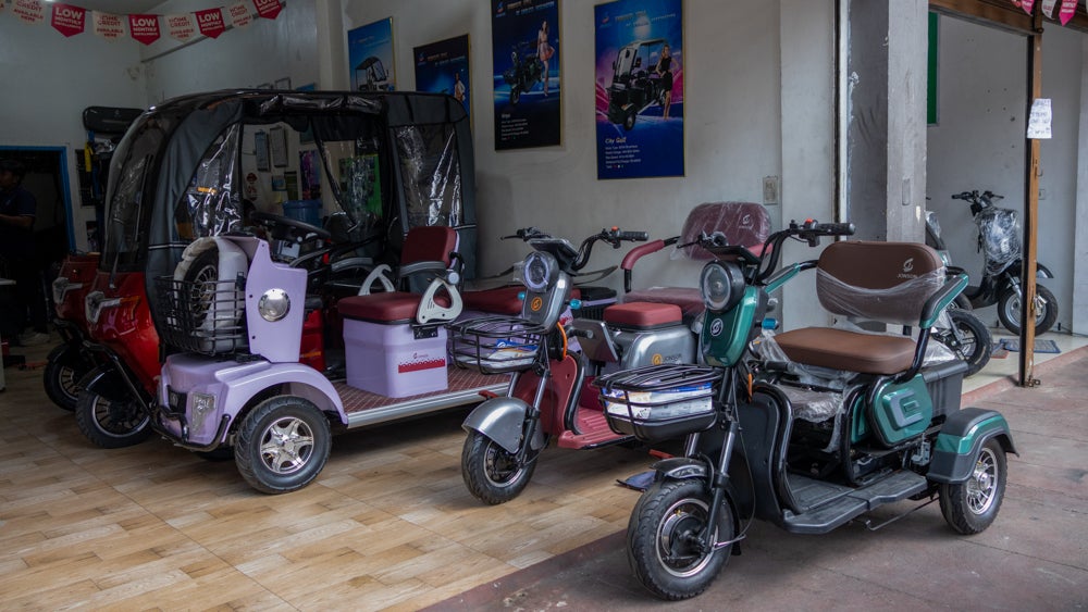 A photo of an electric three-wheeler store showcasing multiple designs.